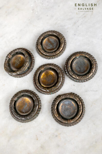 A set of small ornate brass drawer pulls