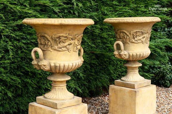 Impressive urns with garlands on plinths 