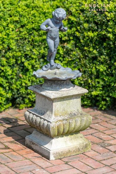 Old lead cherub birdbath fountain on plinth
