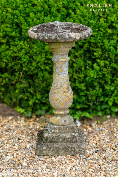 Old weathered composite stone birdbath